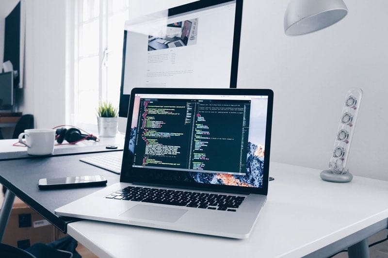 Laptop displaying code on a desk